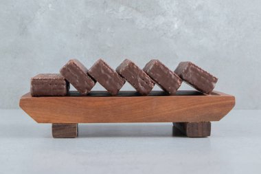 Çikolata kaplı gofretler mermer zemin üzerinde ahşap bir tabakta. Yüksek kalite fotoğraf