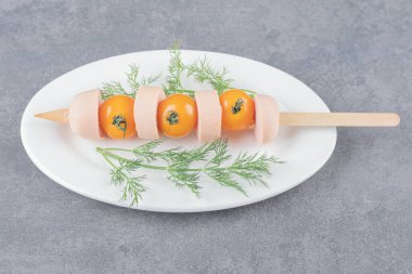 Kaynamış sosisli ve kiraz sarısı domatesli beyaz tabak. Yüksek kalite fotoğraf