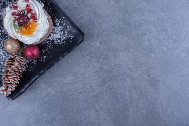 Kremalı hamur işleri ve şekerli jöleli şekerlemelerle dolu karanlık bir tahta. Yüksek kalite fotoğraf