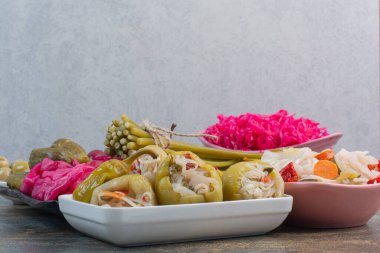 Bir tabak dolusu salatalık turşusu ve mermer zemin üzerinde kırmızı tuzlu lahana. Yüksek kalite fotoğraf