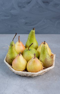 Mermer arka planda beyaz bir sepette küçük bir demet armut. Yüksek kalite fotoğraf