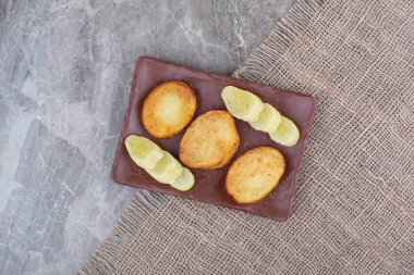 Kızarmış patates dilimleri ve tabakta salatalık turşusu. Yüksek kalite fotoğraf