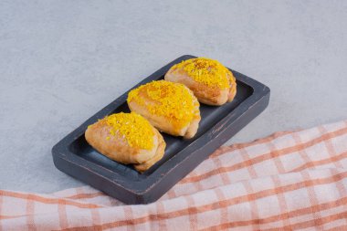 Siyah tabakta sarı hindistan ceviziyle süslenmiş lezzetli bisküviler. Yüksek kalite fotoğraf