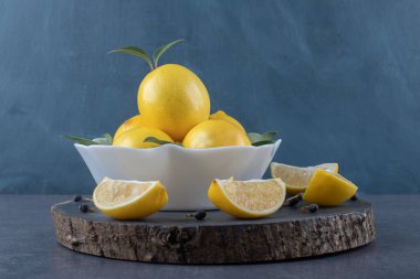 Tahta tahtada bir kase taze limon ve limon dilimi. Yüksek kalite fotoğraf