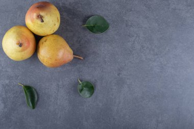 Gri zemin üzerinde taze organik üç sarı armut. Yüksek kalite fotoğraf