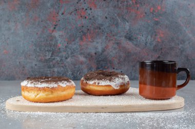 Lezzetli çörekler ve kar tanesi süslemeli bir fincan çay mermer zemin üzerine Hindistan cevizi tozu serpiştirilmiş bir panoda. Yüksek kalite fotoğraf
