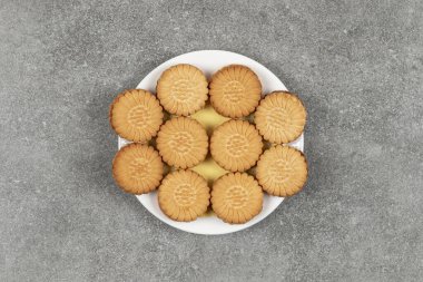 Beyaz tabakta kremayla dolu lezzetli kurabiyeler. Yüksek kalite fotoğraf