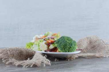 Lahana, karnabahar, brokoli, havuç ve mermer arka planda pancar dilimlerinden oluşan besleyici salata tabağı. Yüksek kalite fotoğraf