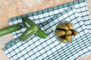Bir kase turşu ve masa örtüsü üzerinde taze salatalık. Yüksek kalite fotoğraf