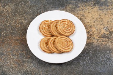 Beyaz tabakta lezzetli susamlı bisküviler. Yüksek kalite fotoğraf
