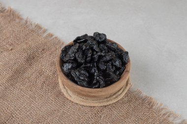 Ahşap bir fincanda kurumuş siyah erikler. Yüksek kalite fotoğraf