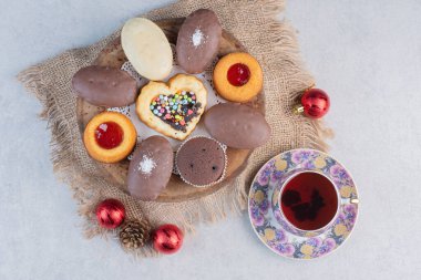 Noel süsleri ve mermer arka planda bir fincan çayla nefis bir tatlı çeşidi. Yüksek kalite fotoğraf