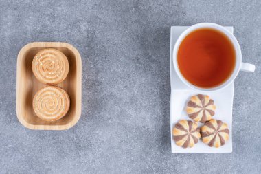 Mermer zemin üzerinde çeşitli bisküviler olan bir fincan siyah çay. Yüksek kalite fotoğraf