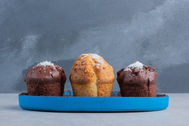 Vanilya tozu kaplı kapkekler mermer arka planda bir tabakta. Yüksek kalite fotoğraf