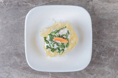 Tabağında havuç olan, mermer zemin üzerinde taze pişmiş spagetti. Merhaba kaliteli fotoğraf.