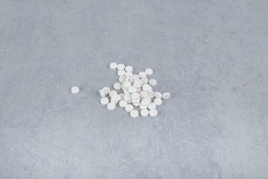 Gri arka planda bir sürü beyaz daire hapı var. Yüksek kalite fotoğraf