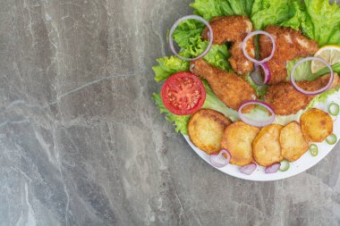 Kızarmış patates ve beyaz tabakta soğanlı tavuk nugget. Yüksek kalite fotoğraf