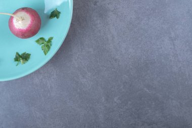 Turp ve yeşillik tabakta, mermer arka planda. Yüksek kalite fotoğraf