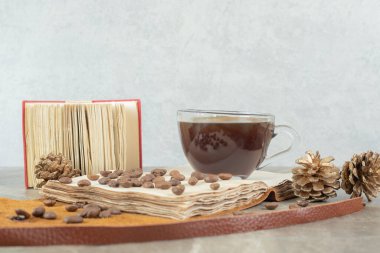 Bir fincan espresso, kahve çekirdekleri ve kozalaklar tahtada. Yüksek kalite fotoğraf