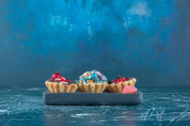 Mavi arka planda küçük bir top kek ve marmelat demeti. Yüksek kalite fotoğraf