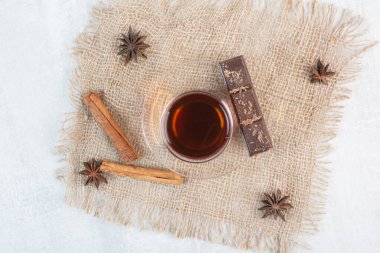 Bir bardak çay, tarçın ve çuval bezinde çikolata. Yüksek kalite fotoğraf