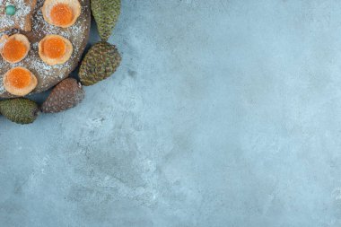 Kurabiye, marmelat ve mermer zemin üzerinde kurumuş elma dilimleri olan bir tahtanın etrafında çam kozalakları. Yüksek kalite fotoğraf