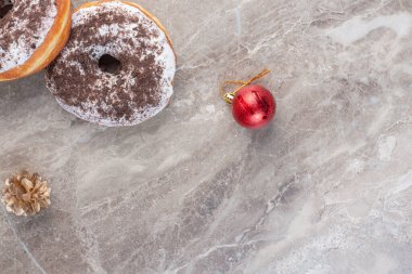 Noel ağacı dekorunun yanında iki çörek ve mermer arka planda bir çam kozalağı. Yüksek kalite fotoğraf