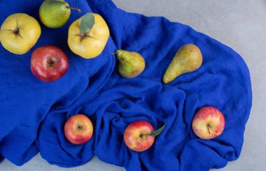 Keskinler, elmalar ve armutlar mermer zemin üzerinde mavi masa örtüsü. Yüksek kalite fotoğraf