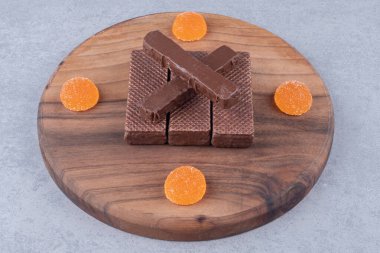 Çikolatalı gofretler ve marmelatlar mermer arka planda tahta tahtada. Yüksek kalite fotoğraf