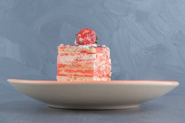 Bir parça kremalı pasta ve turuncu tabakta çilek. Yüksek kalite fotoğraf