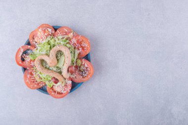 Kalp ve domates dilimi şeklinde haşlanmış sosisler. Yüksek kalite fotoğraf