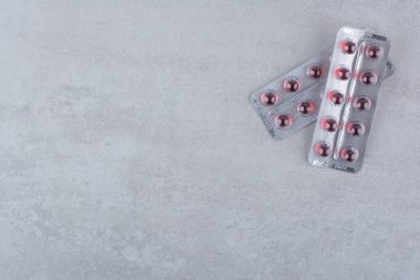 Mermer yüzeyde iki paket kırmızı ilaç. Yüksek kalite fotoğraf