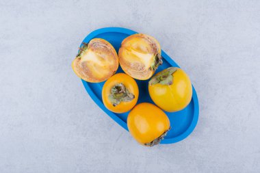 Beyaz arka planda taze hurma dolu mavi bir tabak. Yüksek kalite fotoğraf