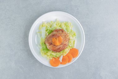 Beyaz bir tabak kızarmış tavuk ve dilimlenmiş havuç. Yüksek kalite fotoğraf