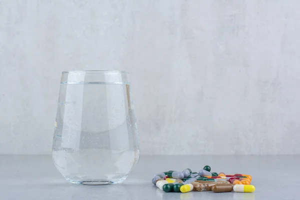 Various pharmaceutical capsules and glass of water. High quality photo