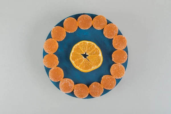 Una Tabla Madera Llena Caramelos Jalea Azucarada Una Rebanada Naranja — Foto de Stock