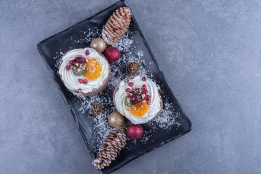 Kremalı hamur işleri ve şekerli jöleli şekerlemelerle dolu karanlık bir tahta. Yüksek kalite fotoğraf