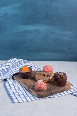 Kekler ve mermer zemin üzerinde tahta bir tahta üzerinde bir çörek. Yüksek kalite fotoğraf