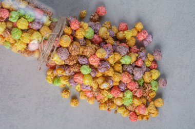 Bir kavanoz renkli patlamış mısır şekeri mermer zemine döküldü. Yüksek kalite fotoğraf