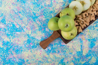 Üst köşedeki tahta üzerinde kraker olan yeşil dilimlenmiş elmalar. Yüksek kalite fotoğraf
