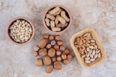 Fındık, fıstık, ayçekirdeği ve mermer yüzeyde patlamış mısır kaseleri. Yüksek kalite fotoğraf