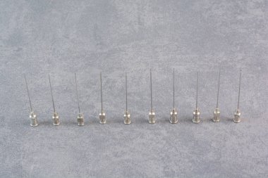 Mermer arka planda bir sürü metal şırınga ucu. Yüksek kalite fotoğraf