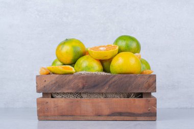 Beyaz arka planda ekşi mandalina dolu ahşap bir sepet. Yüksek kalite fotoğraf