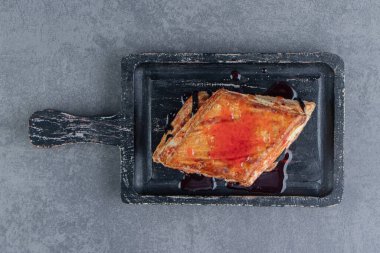 Koyu ahşap bir tahtanın üzerinde lezzetli bir üçgen pasta. Yüksek kalite fotoğraf