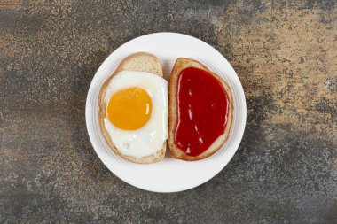 İki kızarmış ekmek, kızarmış yumurta ve beyaz tabakta reçel. Yüksek kalite fotoğraf