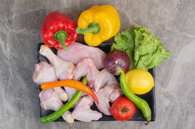 Siyah tabakta çiğ tavuk ve sebze. Yüksek kalite fotoğraf