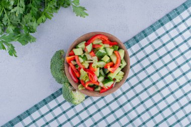 Küçük bir kase sebze salatası, bir demet maydanoz ve mermer zemin üzerinde brokoli. Yüksek kalite fotoğraf