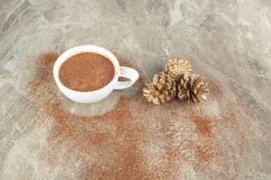 Kapuçino ve kozalak mermer yüzeyde öğütülmüş kahveyle birlikte. Yüksek kalite fotoğraf