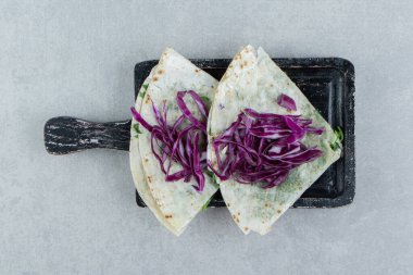 Kırmızı lahanayı doğradım ve mermer arka planda, tepside yarıklar var. Yüksek kalite fotoğraf