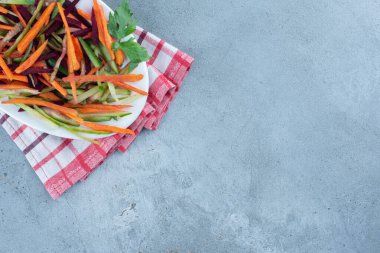 Havuç, salatalık ve pancar dilimlerinden oluşan aperatif mermer zemin üzerinde katlanmış bir masa örtüsü üzerinde. Yüksek kalite fotoğraf